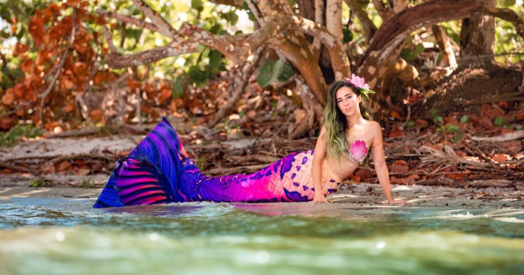 Mermaid Jules poses under a shady tree wearing her All Hallows Eve mermaid tail by Finfolk Productions